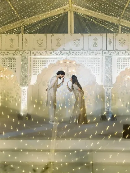 A couple sharing a moment on the Thikri stage, surrounded by a galaxy of lights. This image captures the romance and magic of the sangeet night we created.