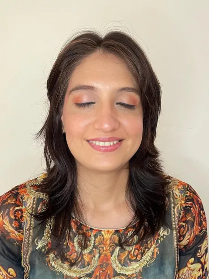 A soft, peachy-orange eyeshadow look. This is a great way to add a subtle pop of color for a daytime event while keeping the overall feel fresh and dewy.
