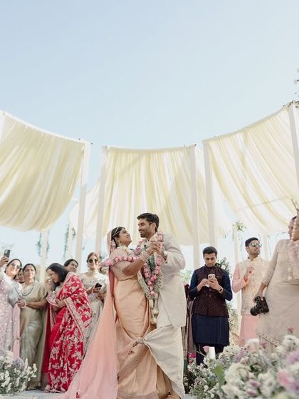 A low-angle shot looking up at the stunning canopy we created for this outdoor wedding. The draped fabric, reminiscent of a blooming flower, filters the sunlight beautifully.