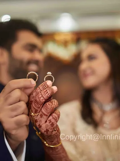 An intimate ring shot with the couple looking at each other in the background. This composition tells a story of connection, with the rings as the central theme.