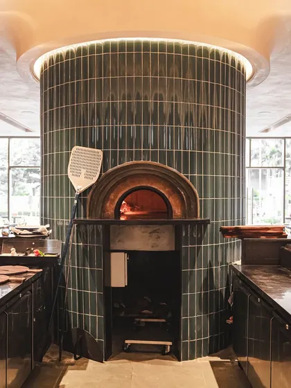 The centerpiece of our Bellandur location: a stunning, green-tiled, cylindrical brick oven that's both a functional kitchen and a design statement. It's a vibe.