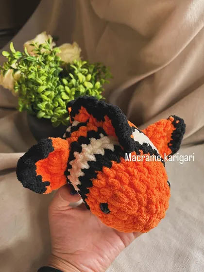 Another view of our crochet clownfish, showing its detailed fins and tail. It's a perfect gift for any fan of sea creatures.
