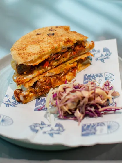 A smashed poee sandwich with a side of slaw, served on custom-printed paper during our pop-up with Klaa Kitchen. It’s the small details that make these events special.
