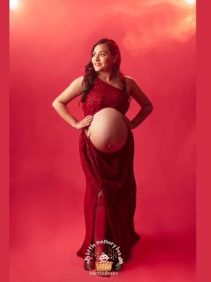 A full-body shot showcasing the stunning red-on-red theme. This powerful and confident pose perfectly celebrates the strength of motherhood.