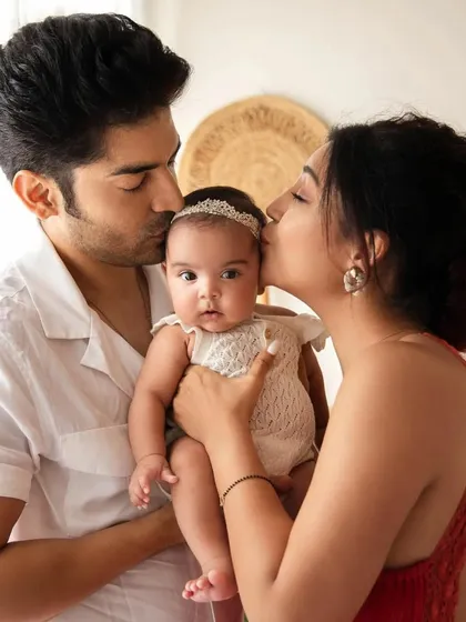 Actress Debina Bonnerjee and her husband Gurmeet Choudhary kiss their baby girl Lianna. A heartwarming family portrait celebrating their new daughter.