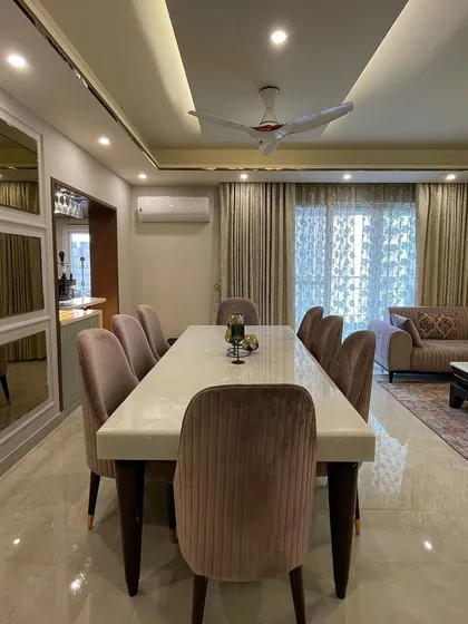 An overview of the dining space, which flows into the living area. The wall of tinted, beveled mirrors makes the room feel larger and brighter by reflecting light and the view.