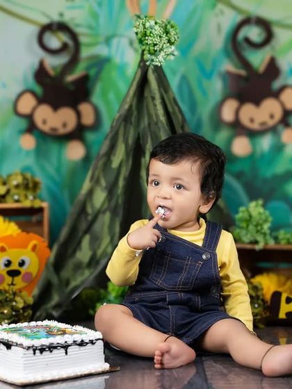 A thoughtful moment amidst the cake chaos, as this little one enjoys a sweet bite of frosting.