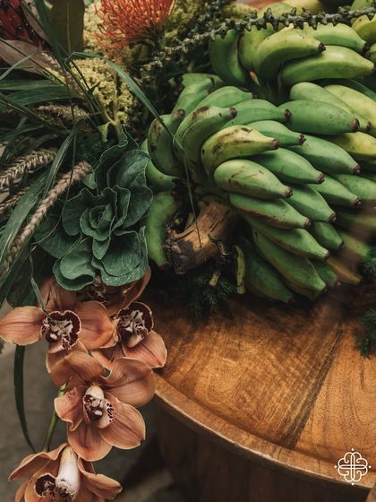 A detail of the fruit and floral arrangements from the 'Orchard of Life' event, featuring bananas and orchids.