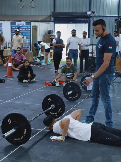 A judge provides encouragement while ensuring proper form during burpees. We are there to push athletes while keeping them safe.