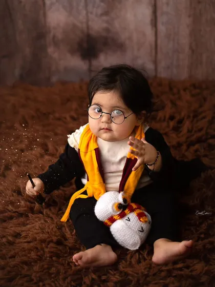 The cutest little wizard in training. He's got his wand, his owl, and a little bit of magic sparkling around him in this fun Harry Potter setup.