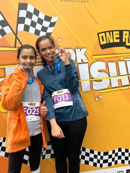 Two young sisters with their finisher medals. The next generation of runners is here.