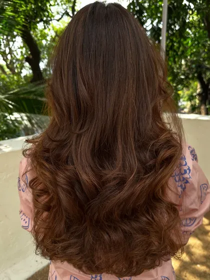 Nothing screams confidence like freshly colored hair. We went for a rich chocolate brown with subtle highlights, styled with big, bouncy waves for a glamorous finish.