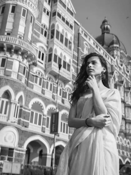 Another black and white shot, this time a wider angle that showcases the grand architecture of the Taj hotel, making the model look elegant and thoughtful.