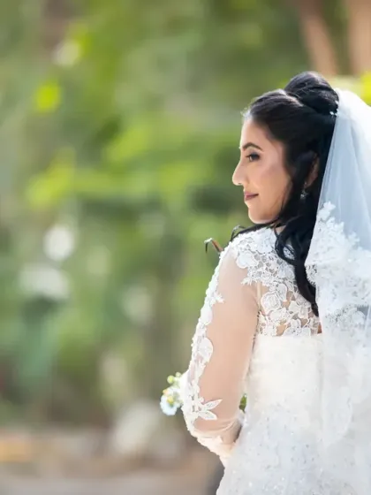 A lovely, candid-style bridal portrait from behind. This shot captures a natural moment and highlights the beautiful details of her hair and dress.