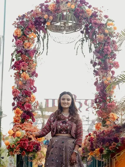 The bride standing under a magnificent floral arch, a perfect entrance piece for the 'Terracotta Tales' theme.