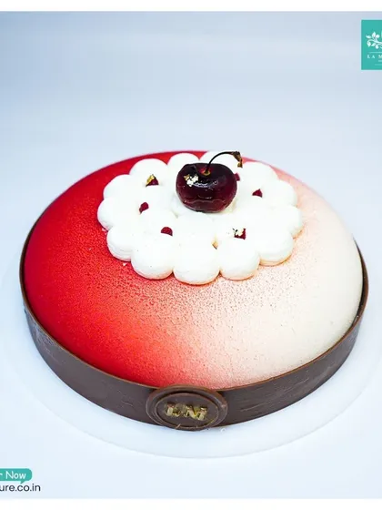 A top-down perspective of the Black Forest Revisited cake, showcasing the beautiful gradient effect and the central cherry decoration.