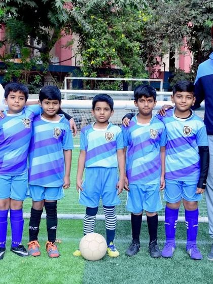 Our Under 8 team posing with their coaches. We maintain a healthy coach-to-player ratio to ensure personalized attention.