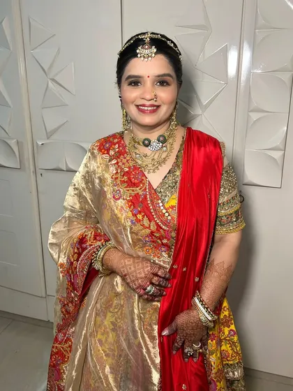 A full-length shot of the mother of the bride, looking regal and elegant in her traditional attire. The makeup is designed to complement her outfit and jewelry perfectly.