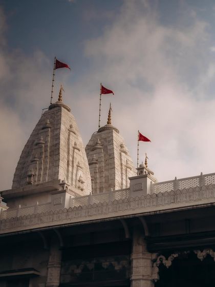 The temple spires against a cloudy sky, setting the scene for a sacred ceremony. I believe in capturing the environment to give context to the day.