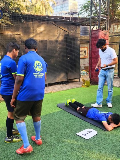 Power, passion, and perseverance. A coach times a player during a fitness test, while another player stands ready, showcasing our focus on measurable progress.