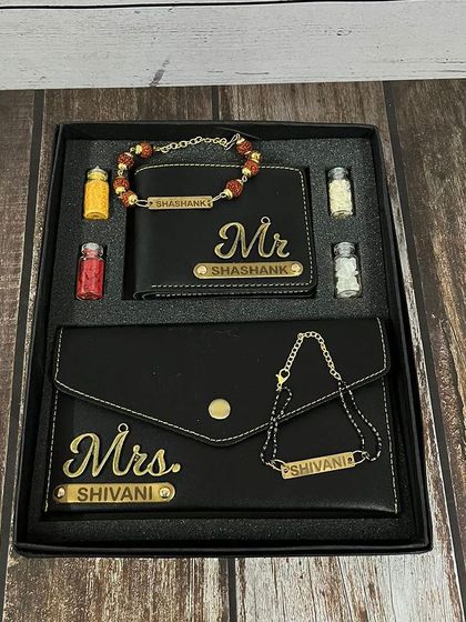The bhai-bhabhi wallet and rakhi combo shown in a sleek black leather finish with "Mr." and "Mrs." charms.