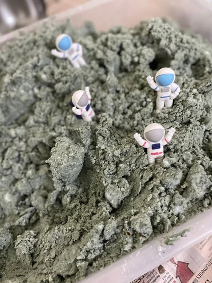 A sensory bin filled with moon sand and astronauts, perfect for a Star Wars or space-themed party. This allows for hours of imaginative, hands-on play.