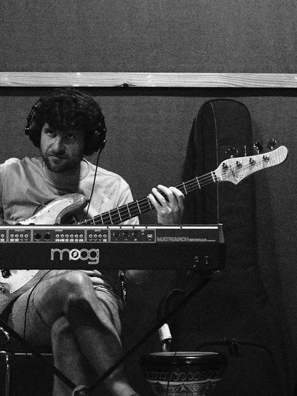 Michael League on bass and Moog synth during a rehearsal. This black and white shot captures his concentration as he builds the harmonic and rhythmic foundation.