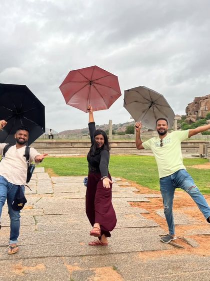 A playful "Singin' in the Rain" moment during a light shower in Hampi.