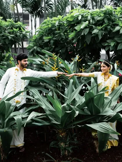 A creative portrait of the couple reaching for each other through lush greenery, inspired by classic movie scenes.