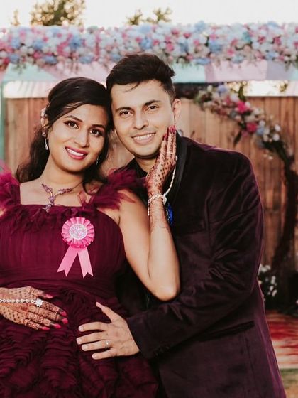 A happy couple portrait from a baby shower. Our ruffled maroon gown is perfect for events, with a fun ribbon to celebrate the occasion.