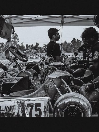 A black and white shot capturing the raw emotion and hard work within the pit garage. The dedication of our technical team is the backbone of our success.