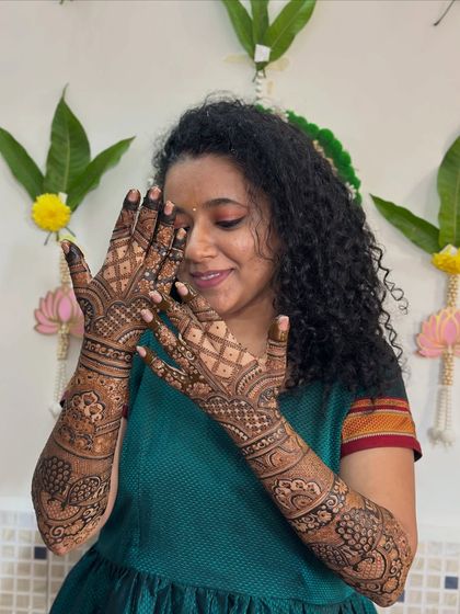 The bride admiring her detailed henna, a beautiful moment captured during the mehendi session.