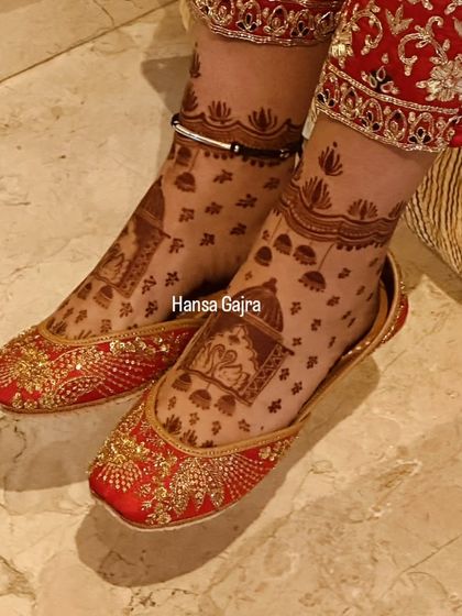 Even with bridal juttis on, the mehendi shines through. This design features a doli (palanquin) motif, peeking out beautifully and adding a touch of tradition to the bride's look.