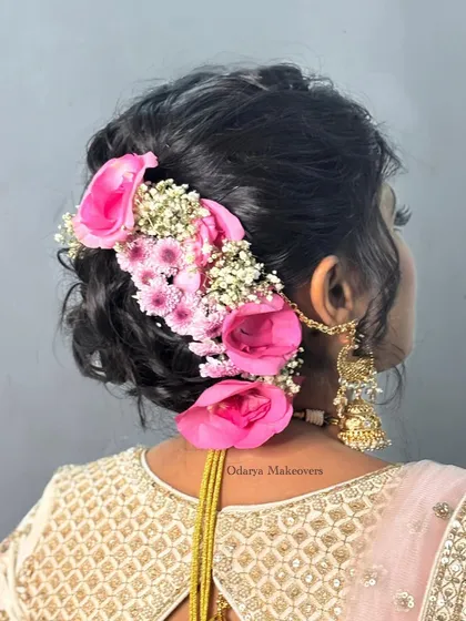 A side view of the floral bun, showing how the flowers are arranged to create a cascading effect. This is a beautiful way to incorporate fresh flowers into your bridal hairstyle.
