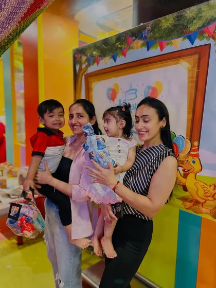 The birthday girl gets a lift to pose with her friend and their moms. These are the joyful, candid moments we treasure.