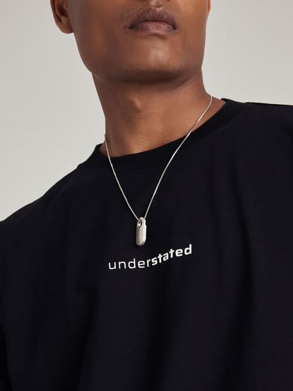 A detail shot of the Understated t-shirt, styled with a silver necklace to showcase versatility.