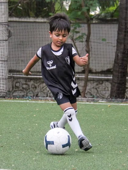 A player in our black training bib practices a close-control dribble, essential for protecting the ball from opponents.