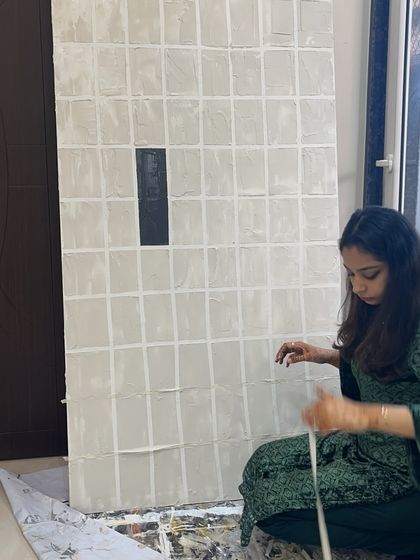 Working on a large gridded piece, carefully masking out the lines with tape. It's a meticulous process, but the clean, geometric result is always worth it.