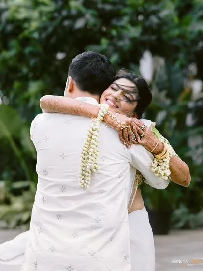 A beautiful, windswept hug. This is the moment of reunion after a long-distance separation, a first look filled with emotion, relief, and overwhelming love.