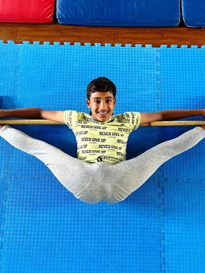 A smiling student proudly displaying his center split. We celebrate every achievement, and mastering a skill like this is a huge confidence booster.