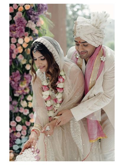 A candid moment from the wedding ceremony, capturing the couple's interaction during a ritual. Their smiles and shared glance show their deep connection even in the midst of tradition.