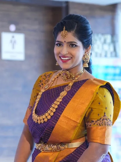 A smile that lights up the room. For her son's naming ceremony, we chose a classic South Indian makeup look with a bright lip that perfectly matched her joyful spirit and the festive occasion.