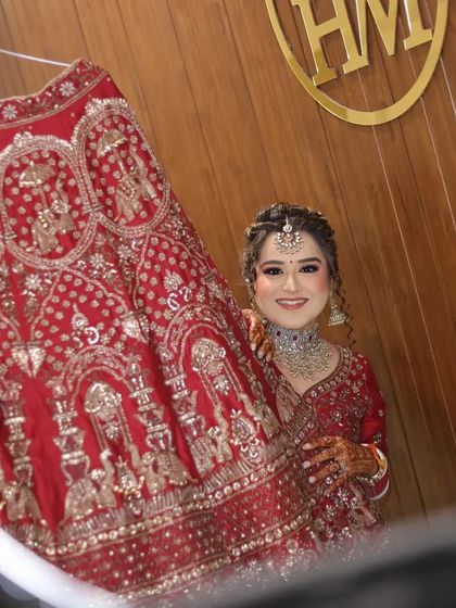 A beautiful portrait of the bride, framed within a ring light as she holds her lehenga. Her happy expression and stunning attire make this a perfect shot.