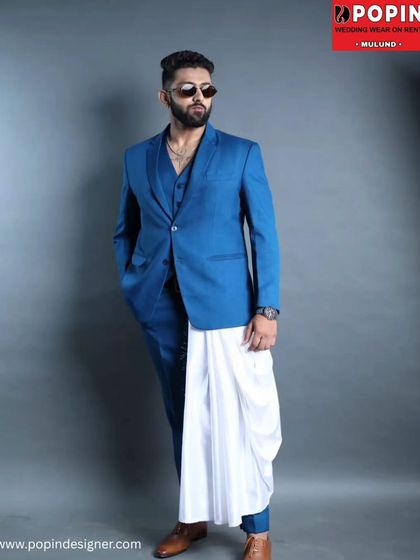 This full-length shot displays the modern fusion styling of the blue three-piece suit paired with a traditional white cloth, showing how you can mix and match styles.