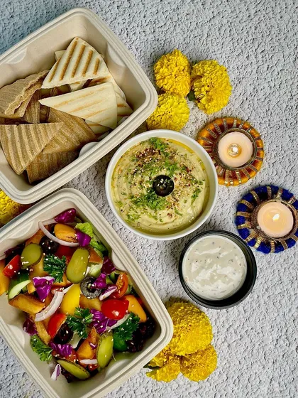 A vibrant overhead shot of our Pita Hummus meal, showcasing the colourful salad and fresh ingredients. It's food that looks as good as it tastes.