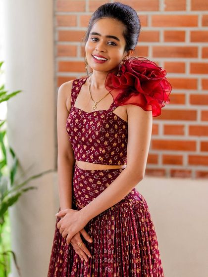 For Nisarga, I also created this beautiful maroon printed co-ord set. The pleated skirt gives it a wonderful twirl, and I added a dramatic ruffled organza flower on one shoulder for a touch of modern flair.
