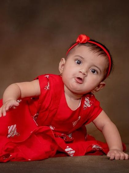 Cuteness overload. Her curious expression and bright red dress make for a lovely portrait.