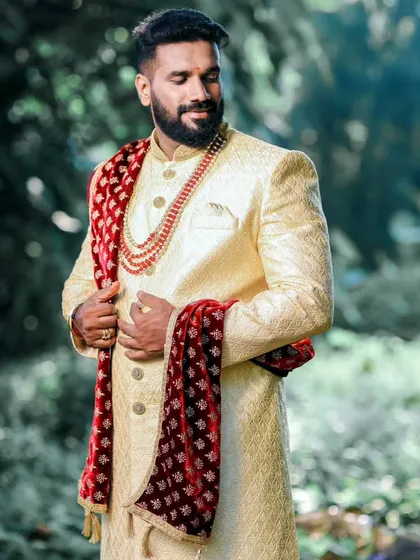 A groom's wedding day look is his ultimate statement. I crafted this custom cream sherwani with a contrasting velvet stole and dhoti pants to create a timeless and royal ensemble for his outdoor ceremony.