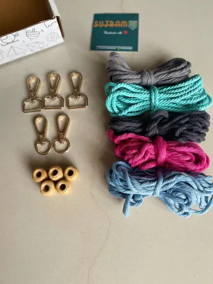 Another view of the high quality macrame supplies included in your art kit. You can see the texture of the 3mm cotton cord and the shine of the metal keychain hooks, all ready for your next creative project.