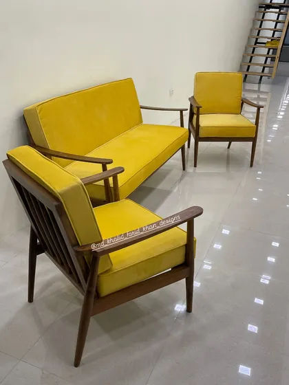 This vibrant mid-century modern sofa set, upholstered in a bold yellow velvet, makes a confident style statement. The set includes a two-seater and matching armchairs, all featuring a solid teak wood frame.